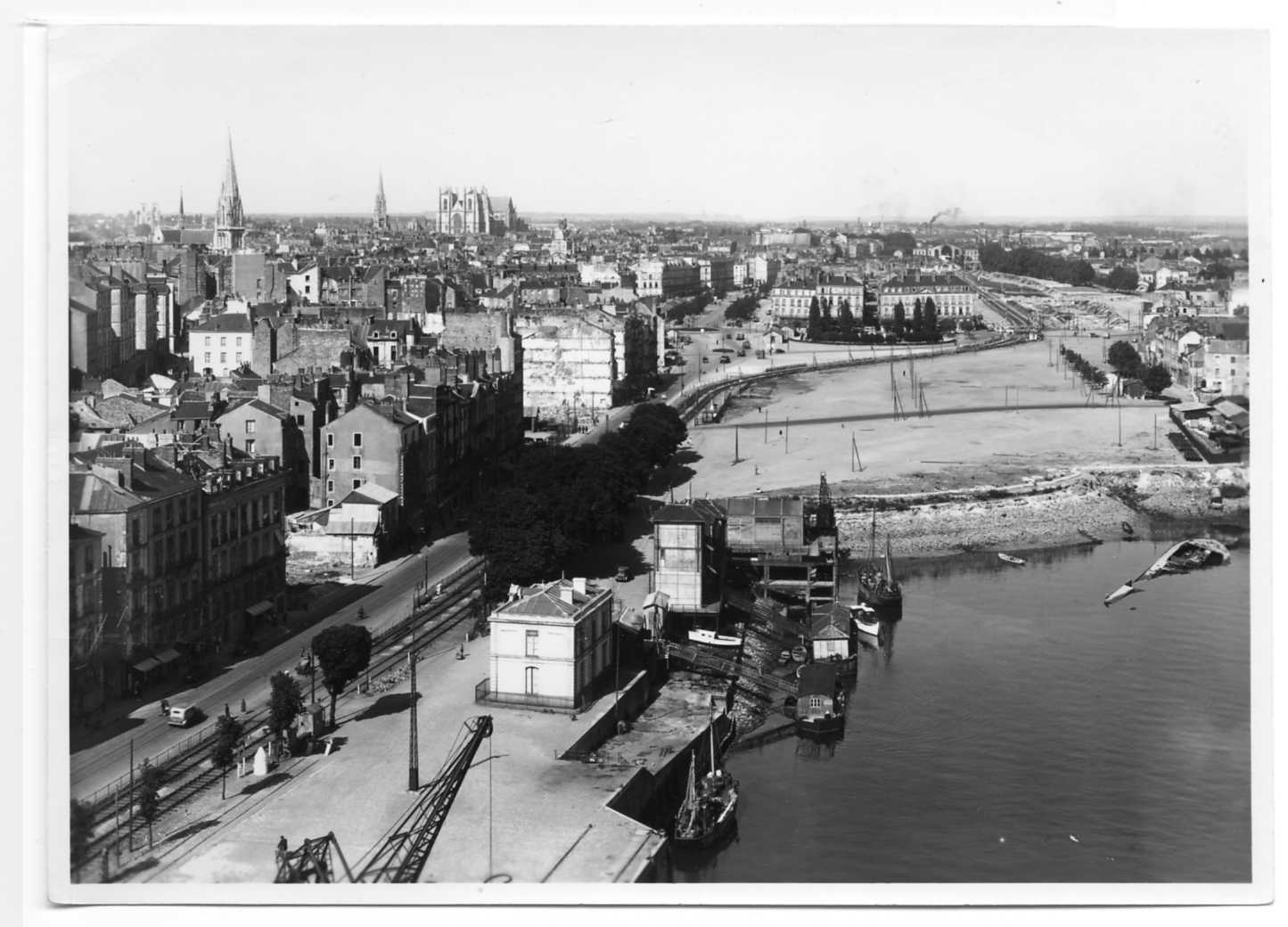Vue prise en 1947 du pont Transbordeur qui montre les aménagements du quai de la Fosse et de la place de la Petite Hollande après le comblement de la Loire (13Fi1334)