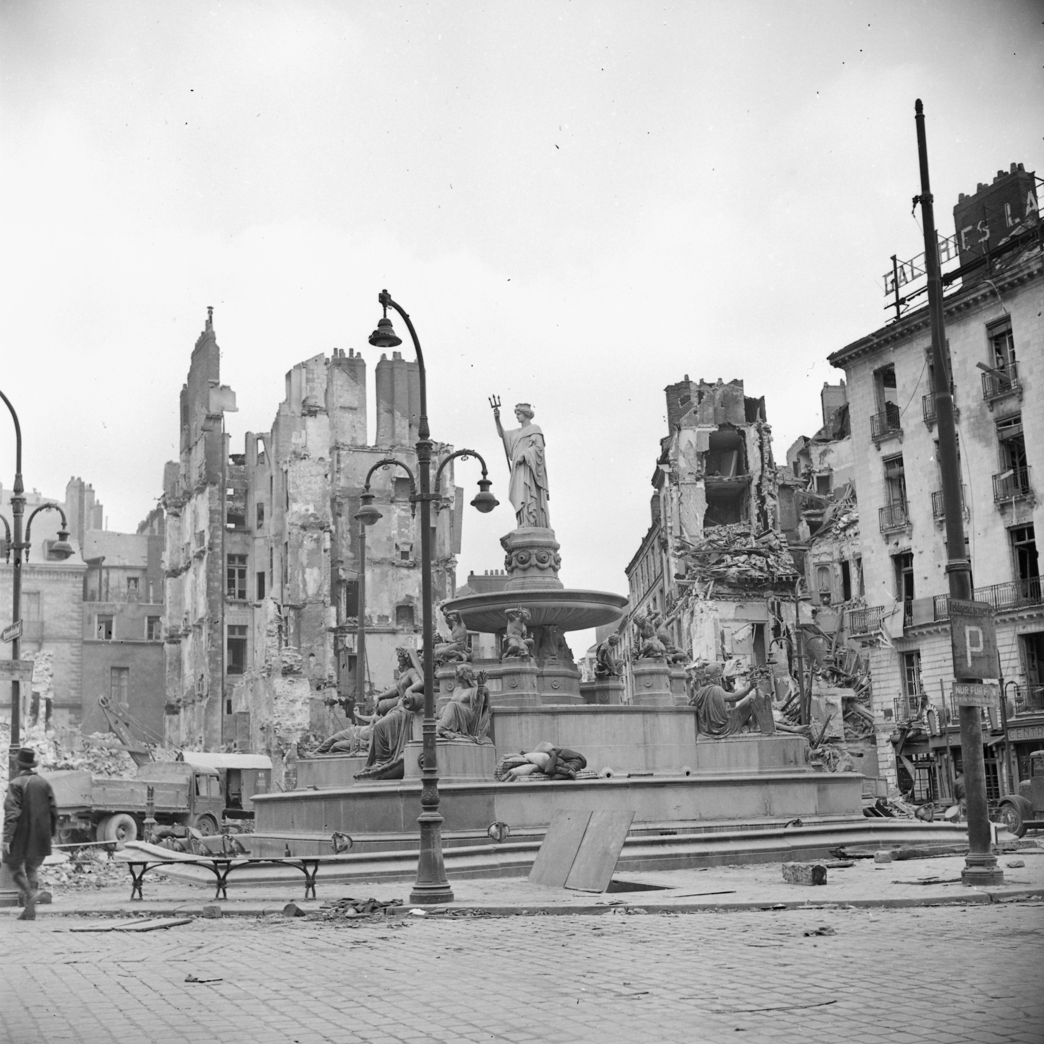 Fontaine de la place Royale entourée d'immeubles détruits par les bombardements, cliché pris en 1943 (23Fi23)