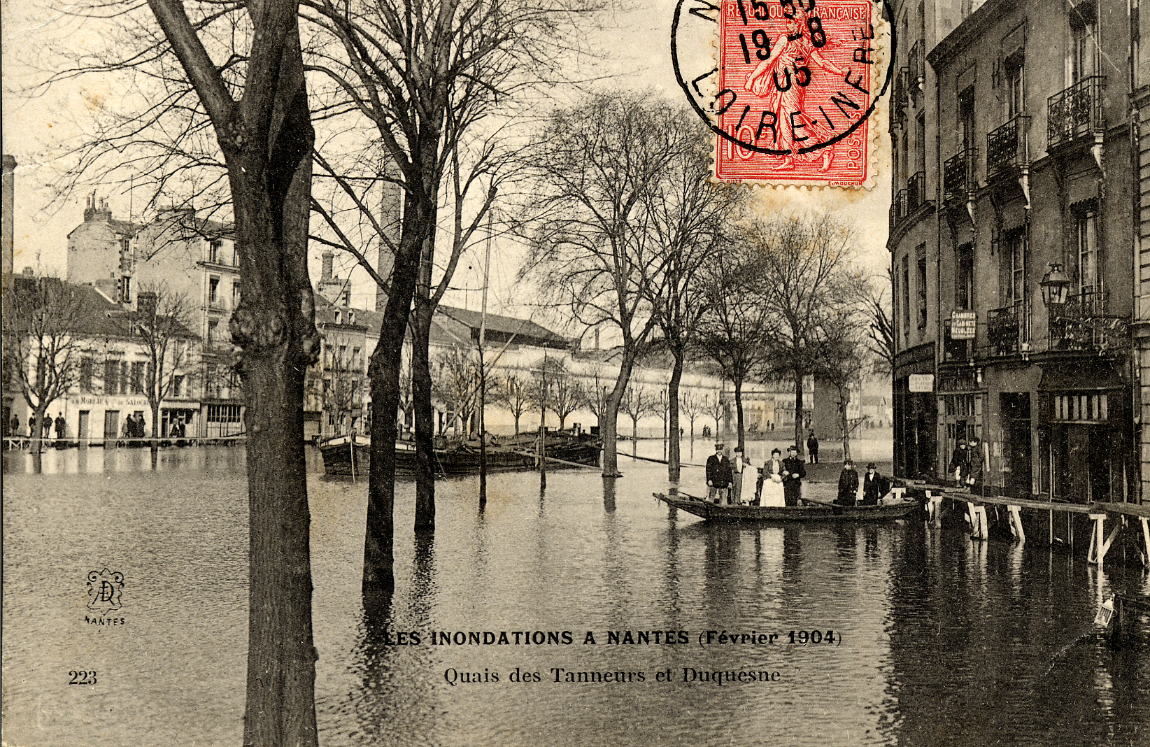 Les quais des Tanneurs et Duquesne. Une barque assure le transport des passagers. En arrière plan, l'usine à gaz et l'entreprise de galoches Moreau (9Fi1787)