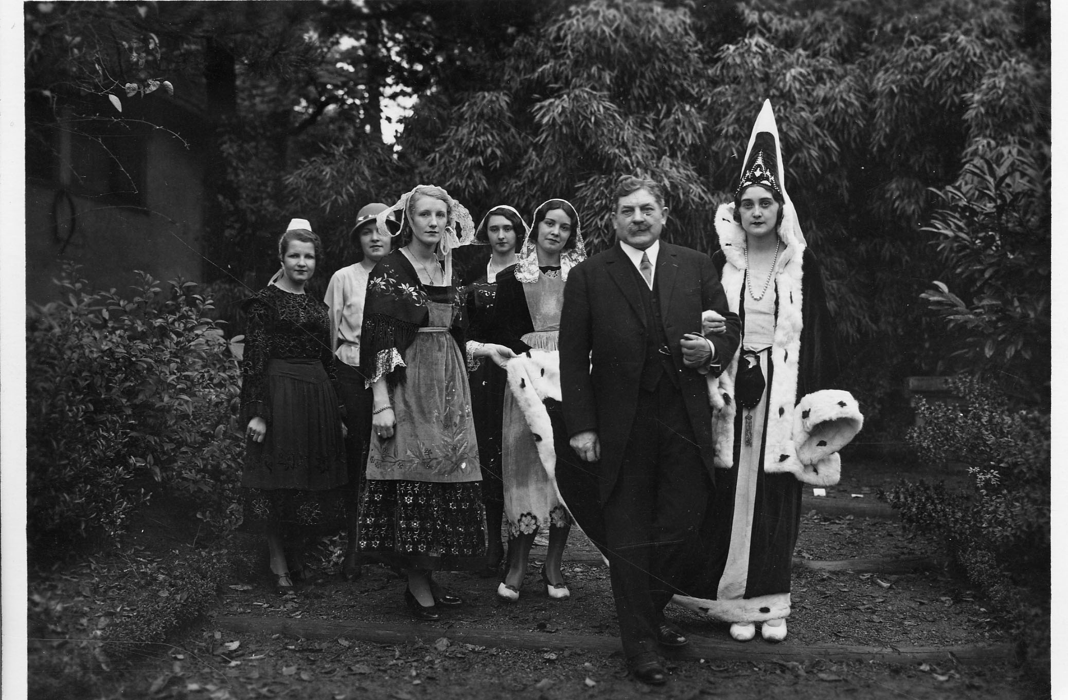 Le président Edouard Herriot au bras d'une jeune fille en costume d' Anne de Bretagne, et entouré de jeunes filles en costumes traditionnels bretons représentant les différentes régions (26Fi316)
