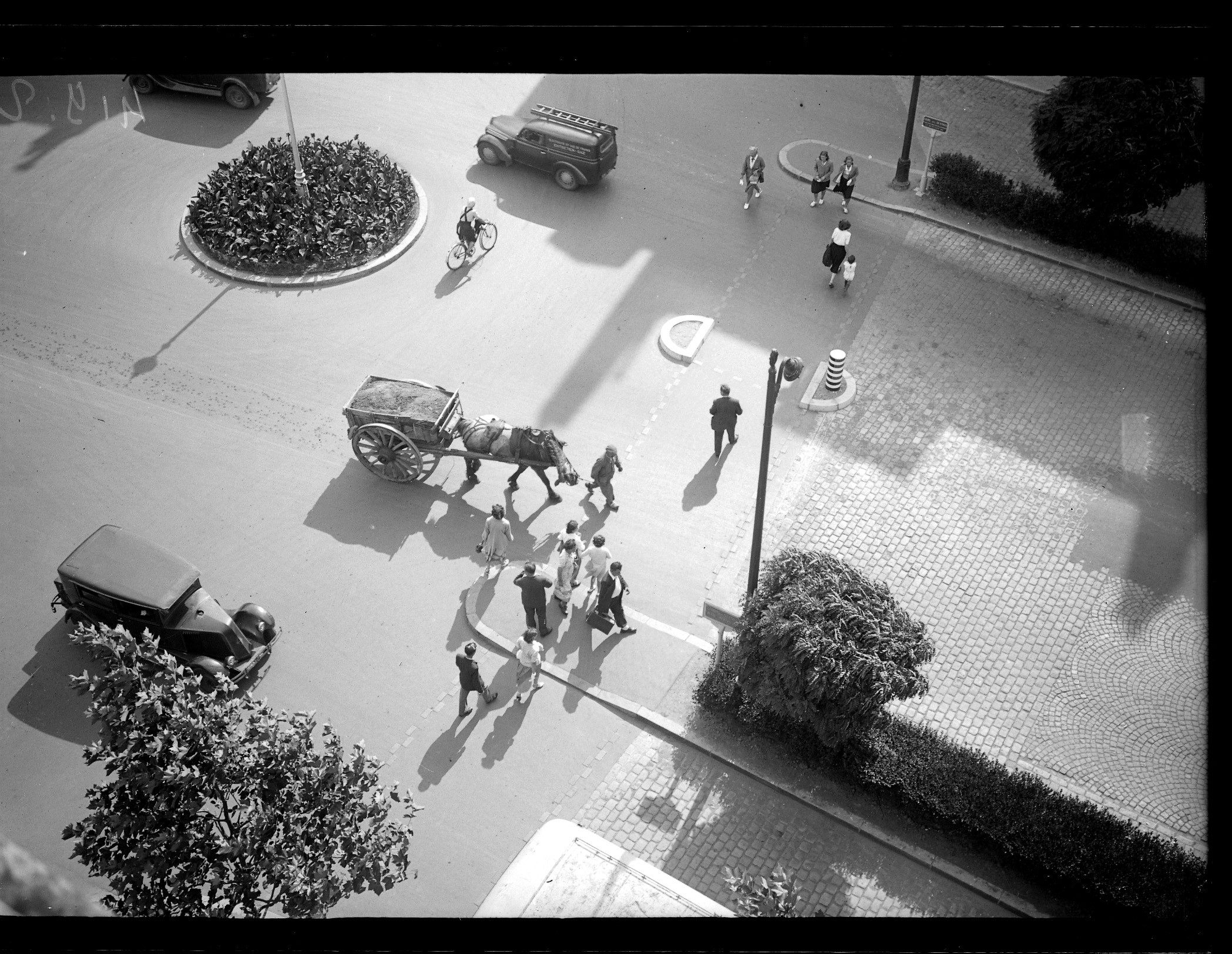 Dans les années 1950, vue aérienne du cours des Cinquante-Otages où se croisent des piétons, des voitures et une remorque de terre tirée par un cheval (10Fi549)
