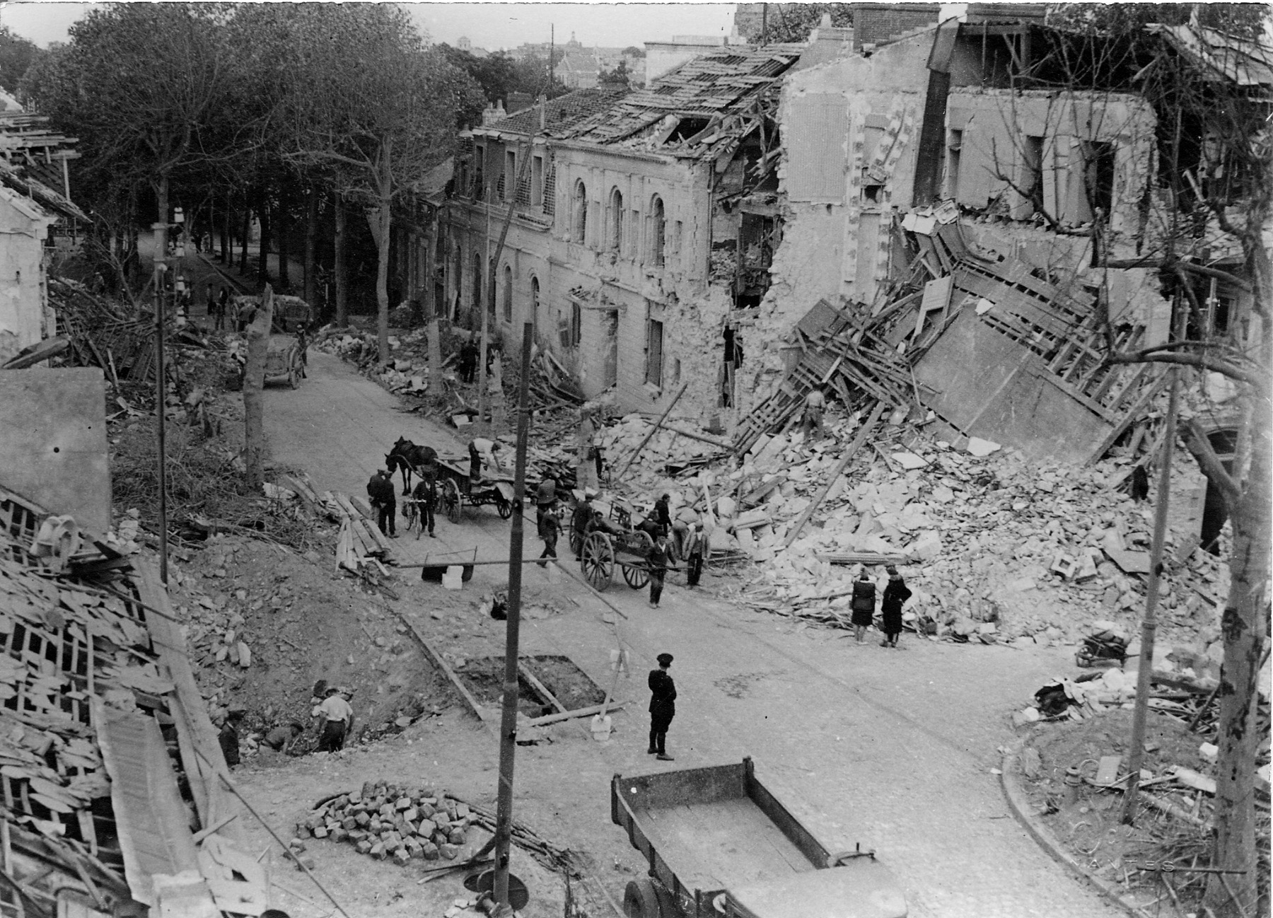 Des charrettes à cheval et à bras pour évacuer les décombres des immeubles détruits par les bombardements sur le boulevard Saint-Aignan, septembre 1943 (22Fi201)