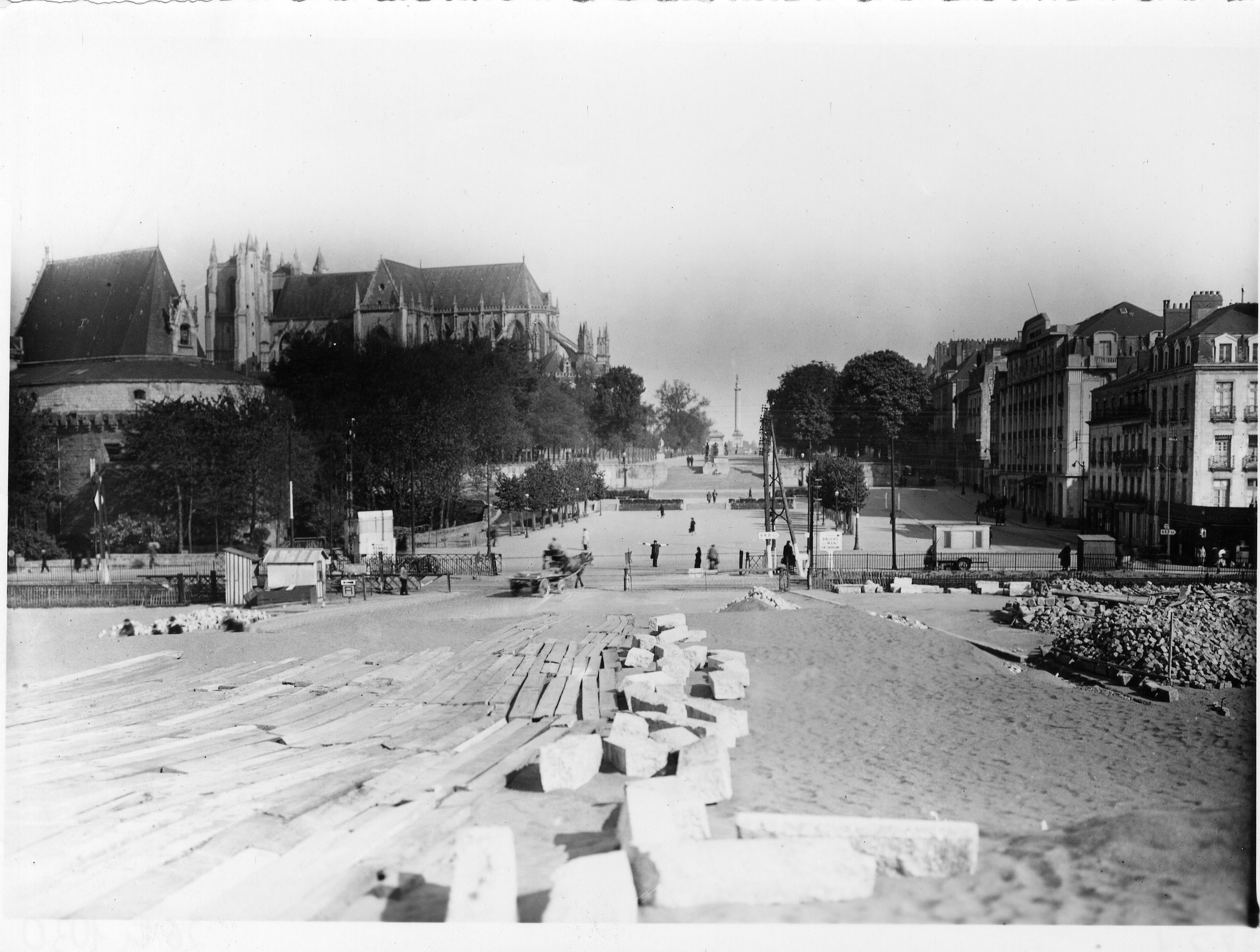Après ces travaux, la place redevient un square mais la fontaine n’y est pas réinstallée. Cette photographie est prise en 1941 lors de la construction du nouveau pont de la Rotonde pour enjamber la voie ferrée qui occupe désormais l'ancien bras de la Loire comblée (26Fi1030)