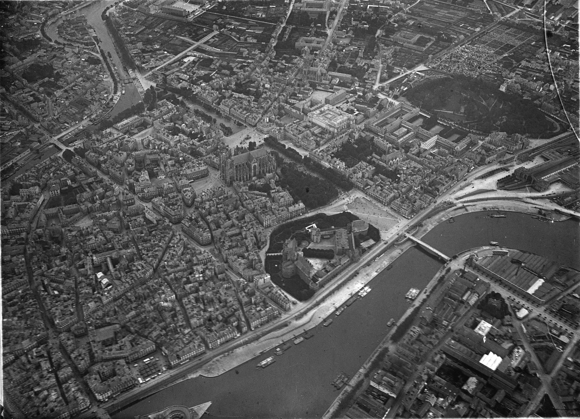 Vue aérienne du centre-ville de Nantes prise en 1907-1908. On y reconnaît la place de la Duchesse-Anne, à droite du château et en bord de Loire (26Fi3087)