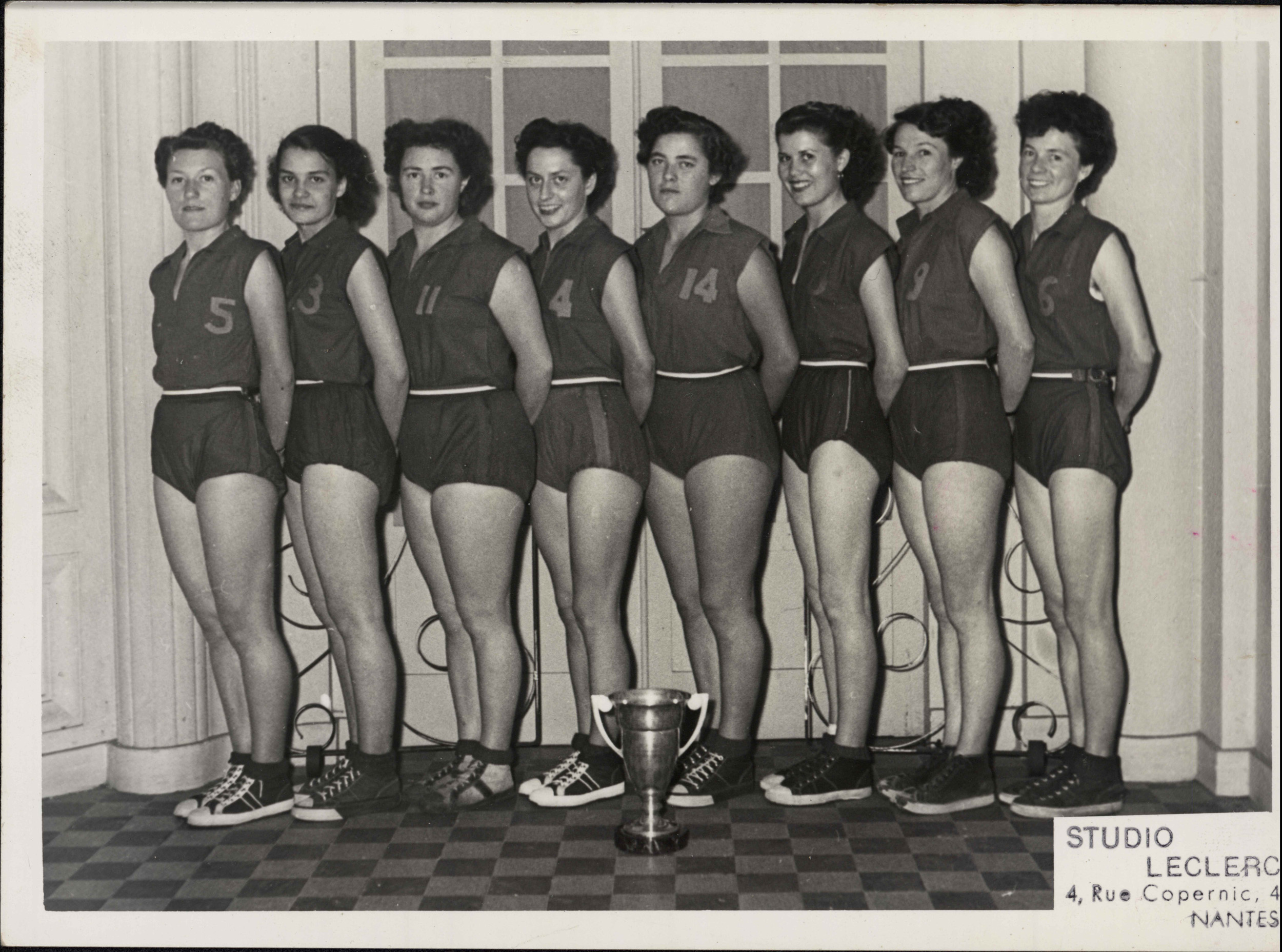 L'équipe de basket féminin du Vélo-Sport-Nantais pose devant une coupe, fin des années 1940 ou années 1950 (123Z1082)