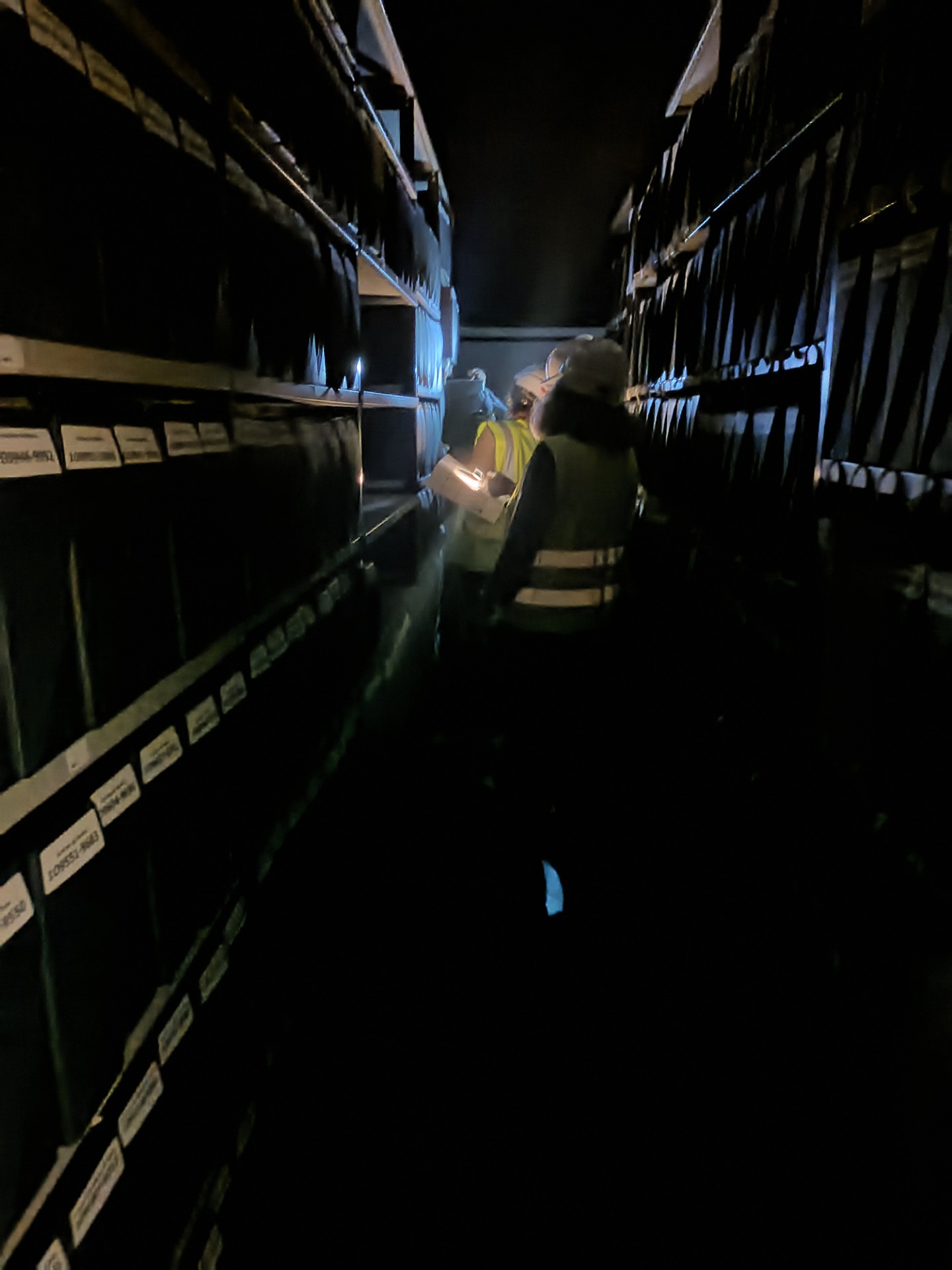 Pour se mettre dans les conditions d'un sinistre provoquant une coupure générale d'électricité, l'un des magasins est plongé dans l'obscurité. L'évacuation des boîtes d'archives se fait à la frontale ! 
